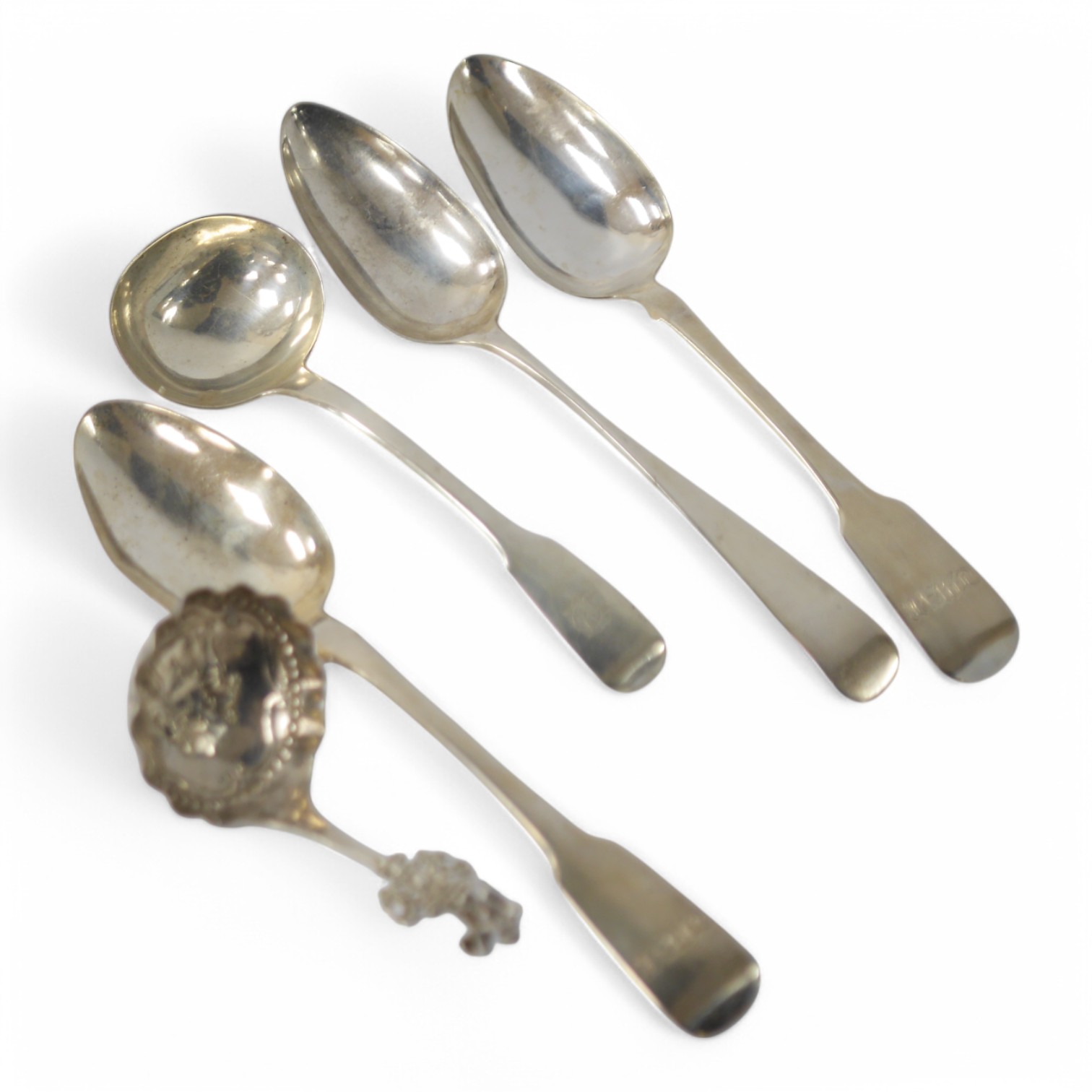 A late 19th century continental silver caddy spoon, with figural terminal, import marks for Sheffield, 1894, together with four assorted 19th century spoons including three table spoons and a sauce ladle, various dates a